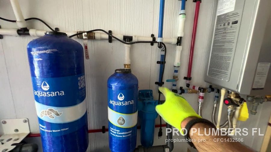 Aquasana whole-house water filtration tanks with PEX manifold next to a gas tankless water heater in Englewood, Florida by PRO PLUMBERS FL, LLC (licence CFC1432506)