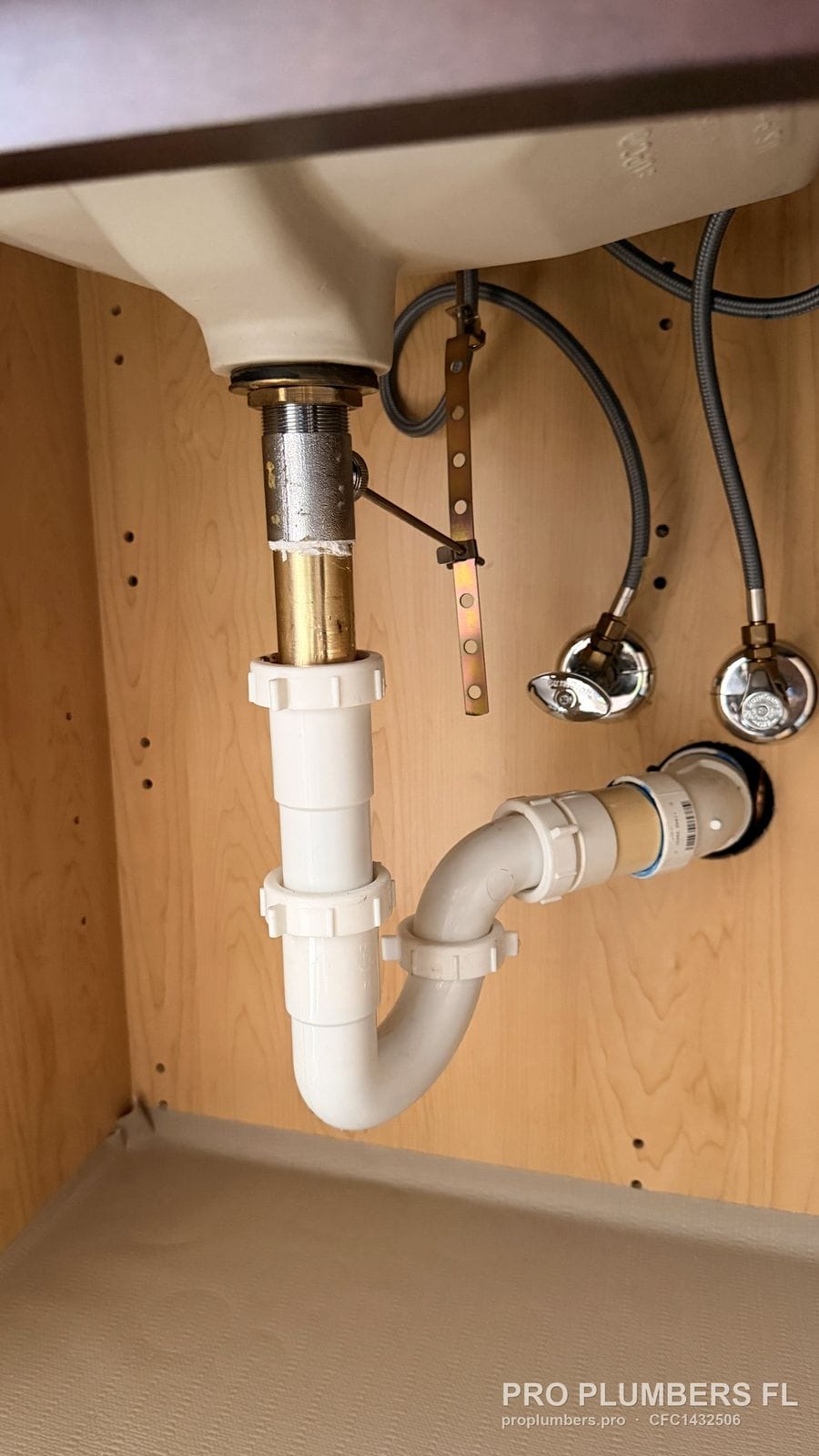 PVC P-trap and trap adapter under a bathroom sink with chrome angle stops in Tarpon Springs, Florida by PRO PLUMBERS FL, LLC (licence CFC1432506)