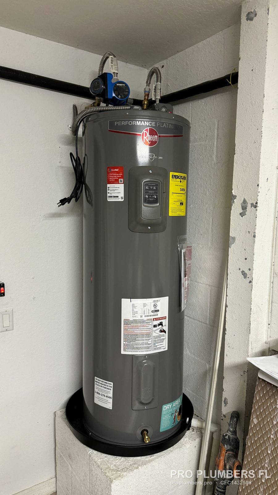Electric tank water heater set in a drain pan with a circulator pump on the hot outlet in Venice, Florida by PRO PLUMBERS FL, LLC (licence CFC1432506)