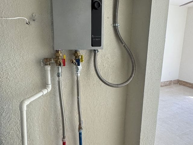 Electric tankless water heater with subpanel and isolation valves on a finished wall in Treasure Island, Florida by PRO PLUMBERS FL, LLC (licence CFC1432506)