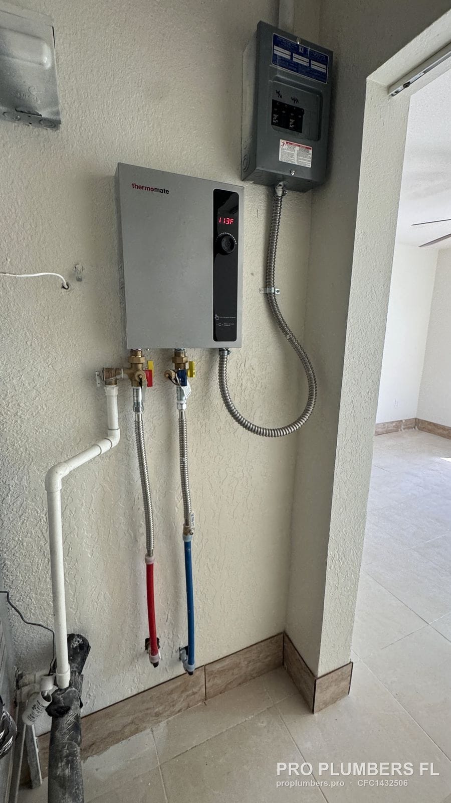 Electric tankless water heater with subpanel and isolation valves on a finished wall in Treasure Island, Florida by PRO PLUMBERS FL, LLC (licence CFC1432506)