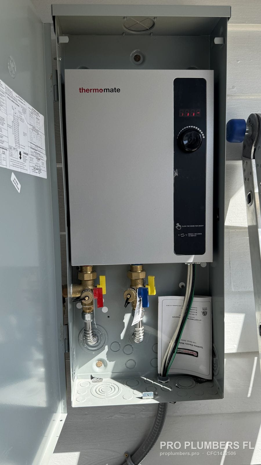 Electric tankless water heater mounted inside a metal outdoor enclosure in Treasure Island, Florida by PRO PLUMBERS FL, LLC (licence CFC1432506)