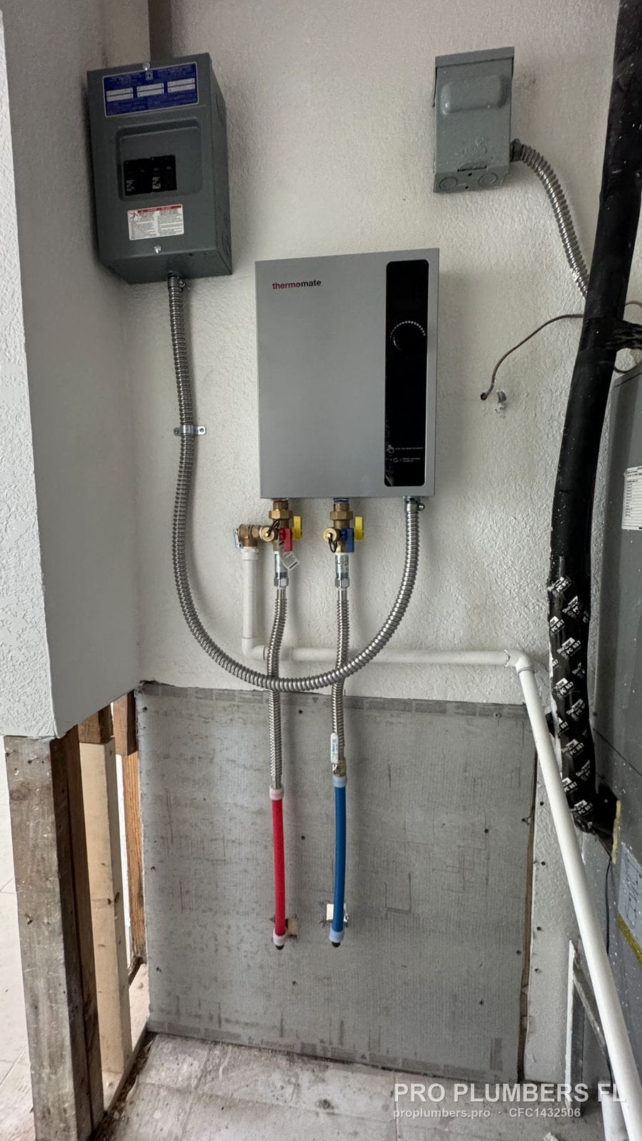 Electric tankless water heater and subpanel with the lower wall still open in Treasure Island, Florida by PRO PLUMBERS FL, LLC (licence CFC1432506)