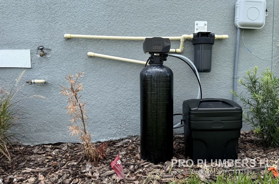 Close view of an exterior water softener with CPVC supply lines and sediment prefilter in Wesley Chapel, Florida by PRO PLUMBERS FL, LLC (licence CFC1432506)
