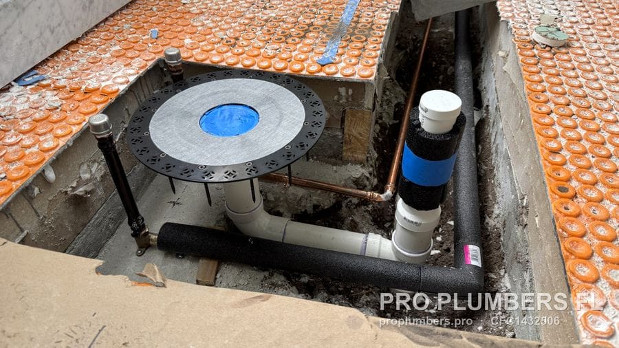 Floor-mount tub filler rough-in plate on adjustable legs with PVC drain and insulated water lines in an opened floor in East Lake, Florida by PRO PLUMBERS FL, LLC (licence CFC1432506)