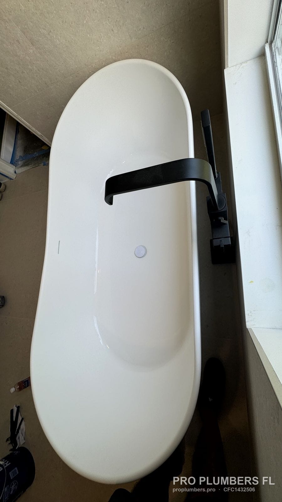 Overhead view of a freestanding tub with the floor-mounted filler spout over the rim in Westchase, Florida by PRO PLUMBERS FL, LLC (licence CFC1432506)