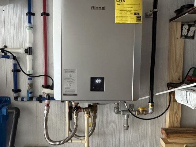 Wall-mounted gas tankless water heater with PVC venting and PEX lines in a utility room in Englewood, Florida by PRO PLUMBERS FL, LLC (licence CFC1432506)