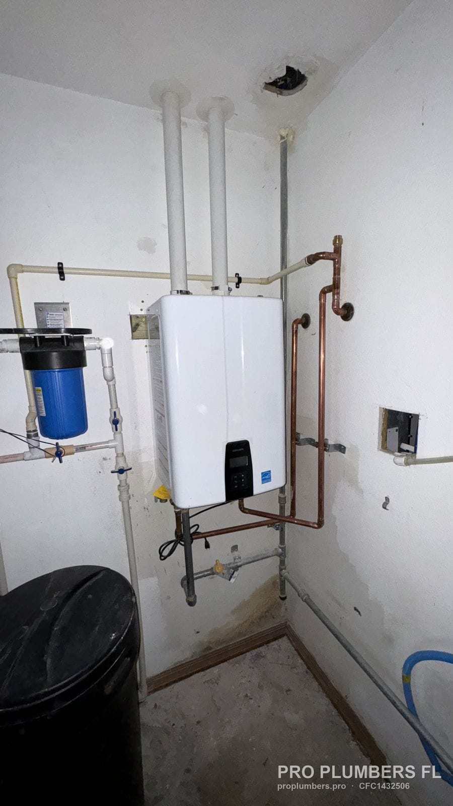 Gas tankless water heater with copper piping and whole-house filter in a utility room in Largo, Florida by PRO PLUMBERS FL, LLC (licence CFC1432506)