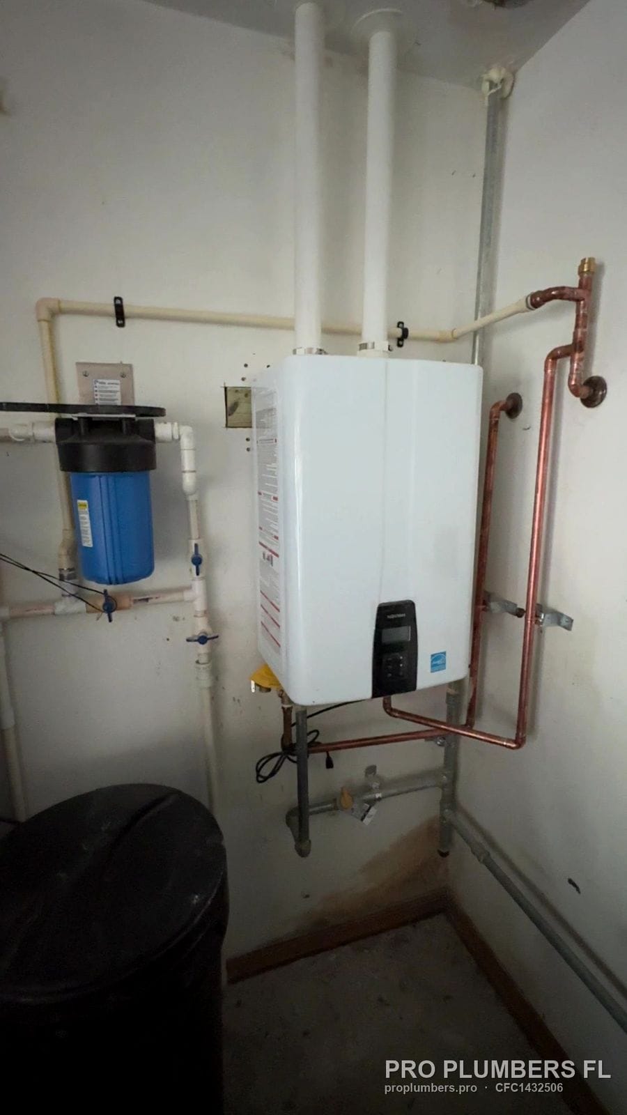Gas tankless water heater with PVC venting, copper lines and whole-house filter in a utility room in Largo, Florida by PRO PLUMBERS FL, LLC (licence CFC1432506)