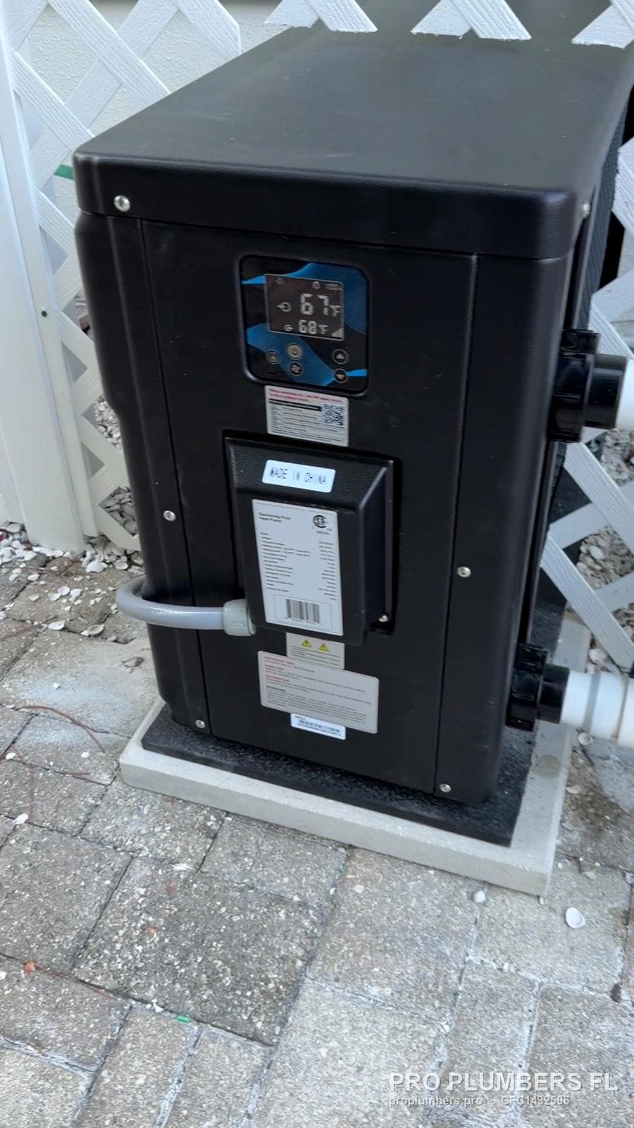 Heat pump pool heater with lit control display on an equipment pad in Palm Harbor, Florida by PRO PLUMBERS FL, LLC (licence CFC1432506)