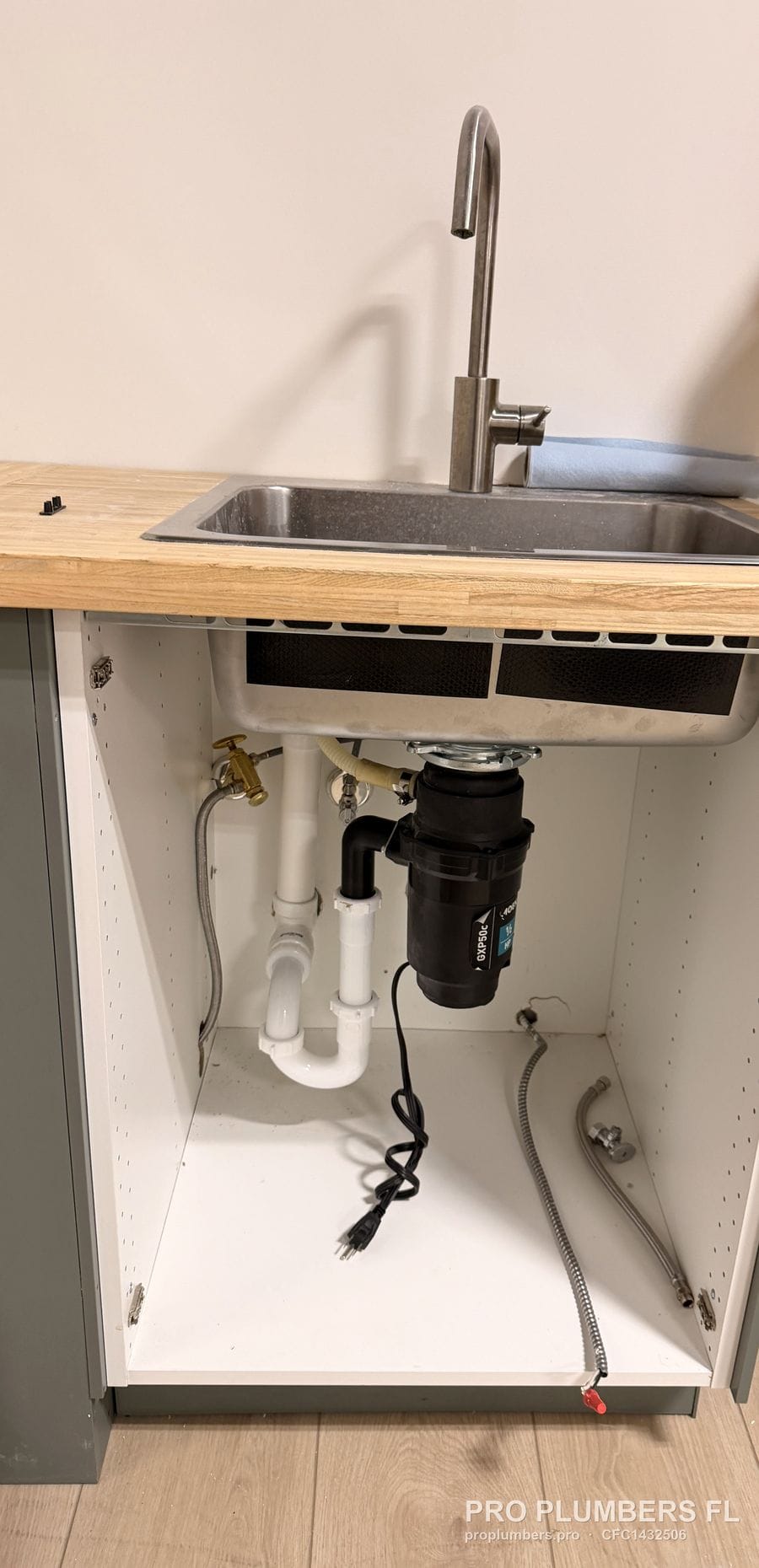 Kitchen sink cabinet with new garbage disposal, PVC trap and pull-down faucet in Largo, Florida by PRO PLUMBERS FL, LLC (licence CFC1432506)