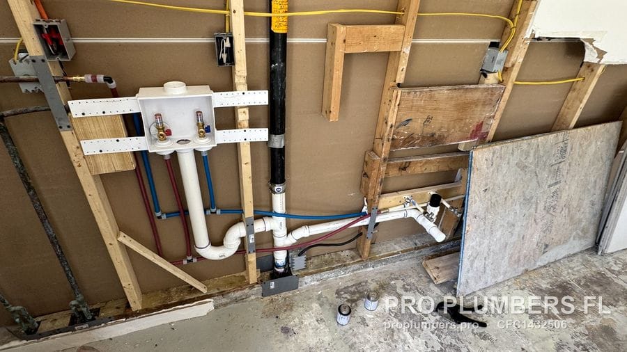 Laundry wall rough-in with washer box, PVC drain and PEX lines across open studs in Hudson, Florida by PRO PLUMBERS FL, LLC (licence CFC1432506)