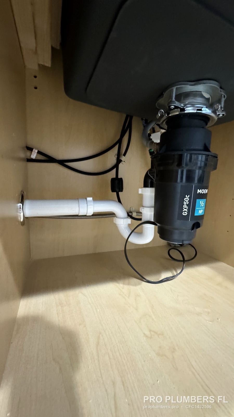 Moen GXP50C 1/2 HP garbage disposal installed under a kitchen sink with PVC drain in Clearwater, Florida by PRO PLUMBERS FL, LLC (licence CFC1432506)