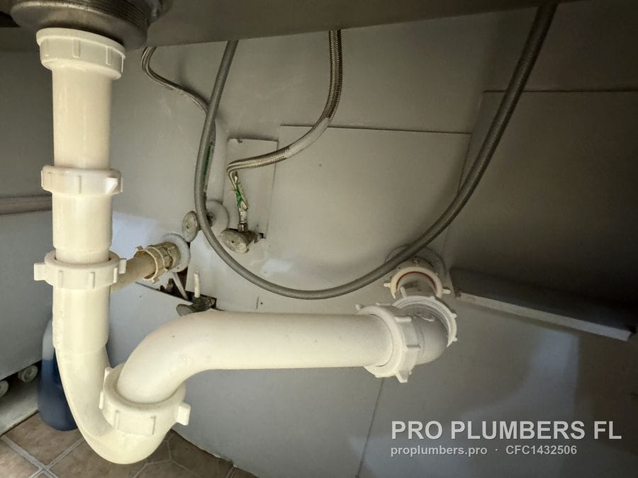 PVC P-trap and trap arm to the wall drain under a sink in Tampa, Florida by PRO PLUMBERS FL, LLC (licence CFC1432506)