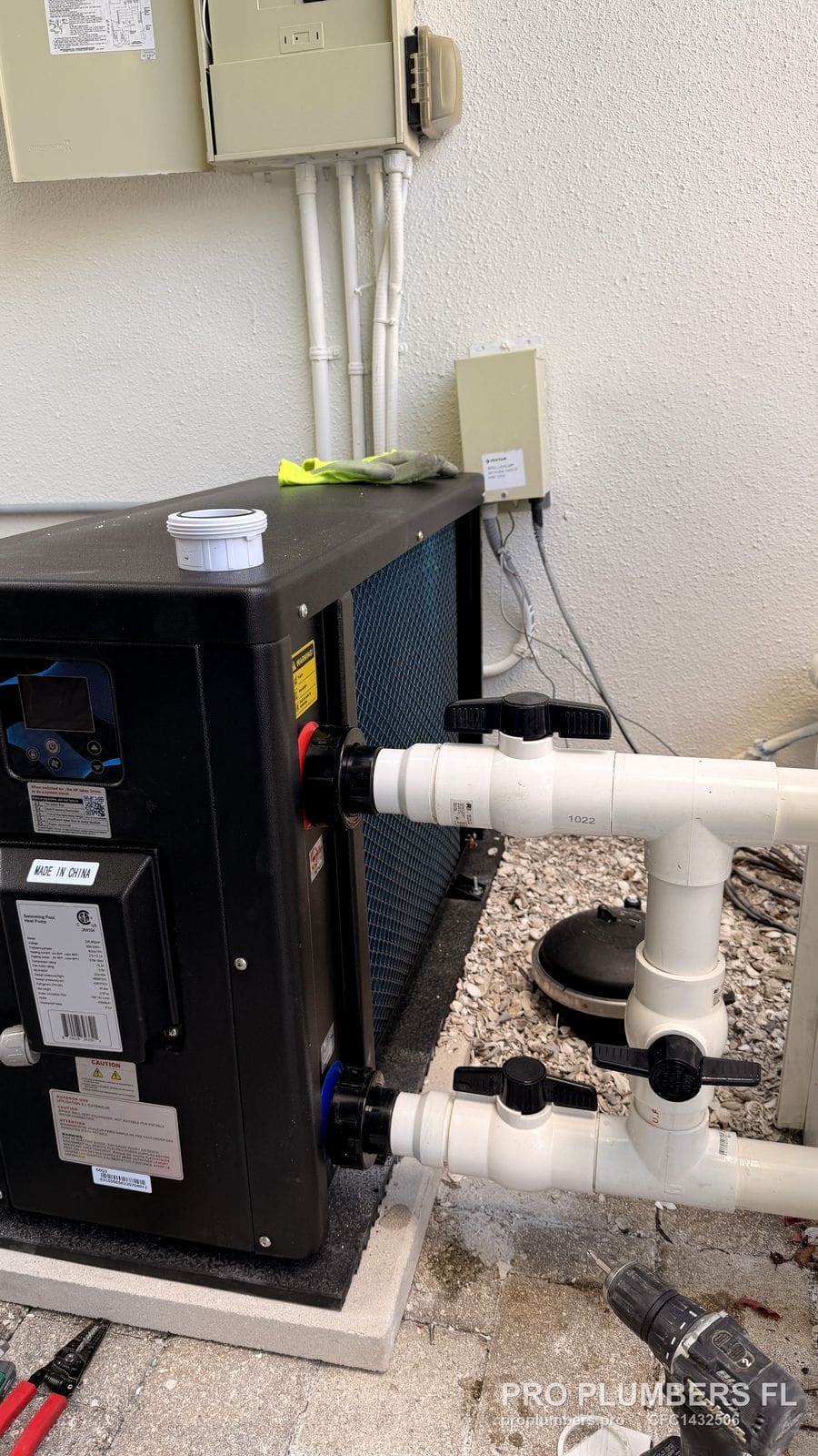 Pool heat pump on a pad with PVC inlet and outlet unions and valves in Palm Harbor, Florida by PRO PLUMBERS FL, LLC (licence CFC1432506)