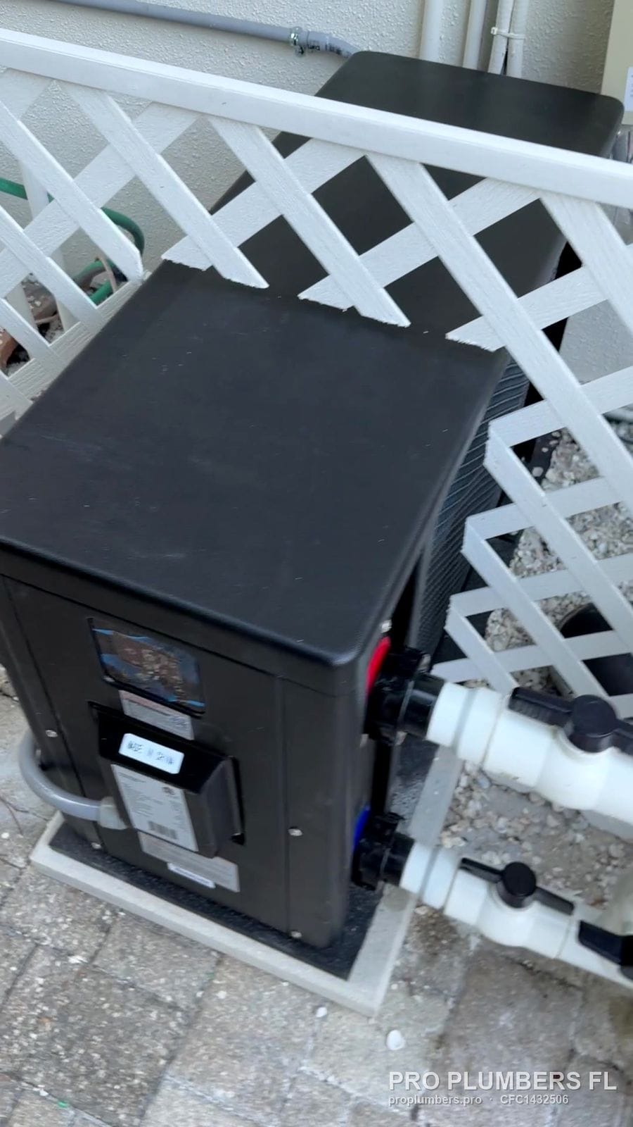 Pool heater tucked behind white lattice screening in Palm Harbor, Florida by PRO PLUMBERS FL, LLC (licence CFC1432506)
