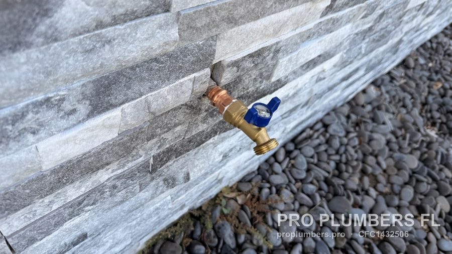 New hose bibb with quarter-turn valve installed through a stone veneer wall in St. Petersburg, Florida by PRO PLUMBERS FL, LLC (licence CFC1432506)