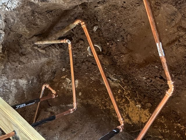 Copper water line branches with press fittings routed through a trench before backfill in Tampa, Florida by PRO PLUMBERS FL, LLC (licence CFC1432506)
