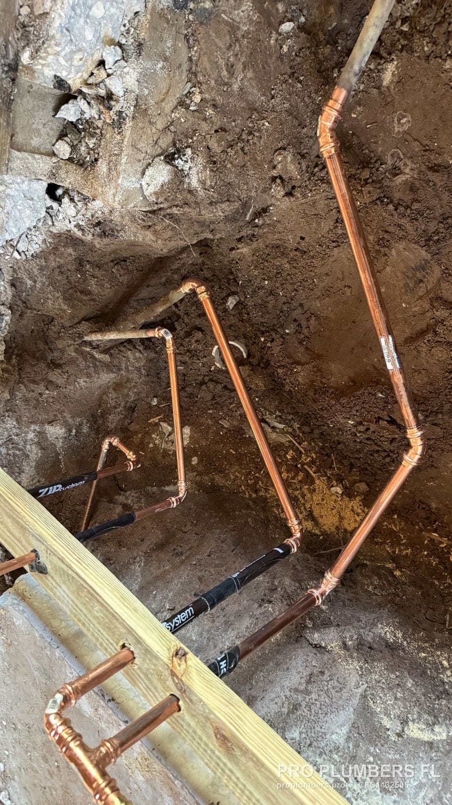 Copper water line branches with press fittings routed through a trench before backfill in Tampa, Florida by PRO PLUMBERS FL, LLC (licence CFC1432506)