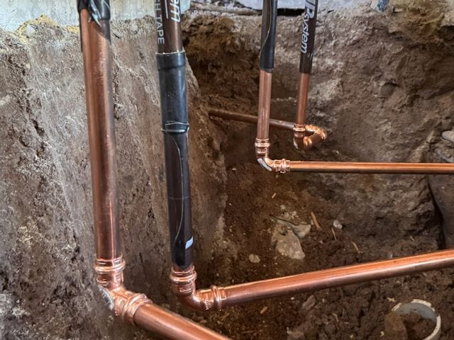 Underground copper water lines with press fittings laid in an open trench during a repipe in Tampa, Florida by PRO PLUMBERS FL, LLC (licence CFC1432506)