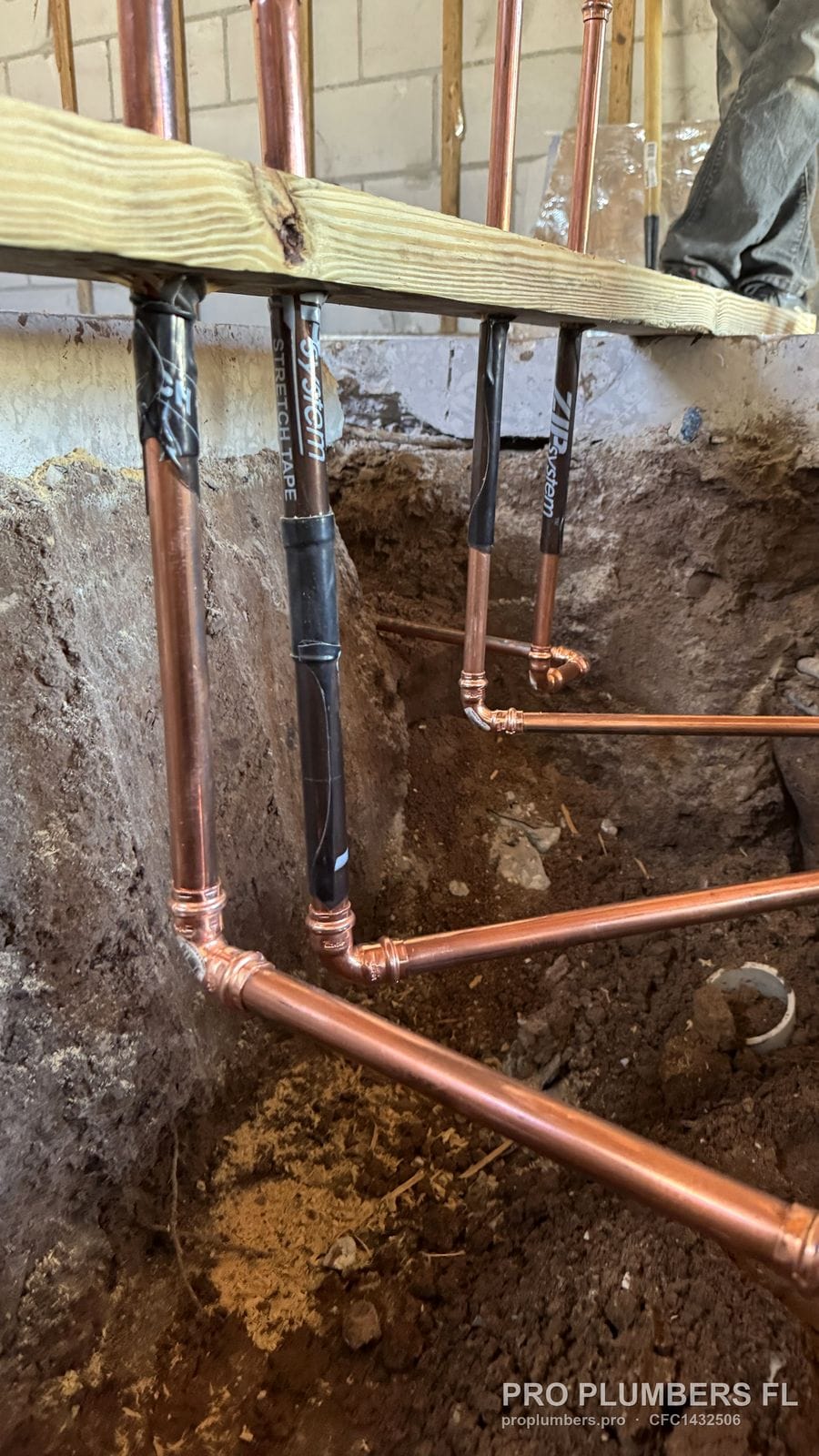 Underground copper water lines with press fittings laid in an open trench during a repipe in Tampa, Florida by PRO PLUMBERS FL, LLC (licence CFC1432506)