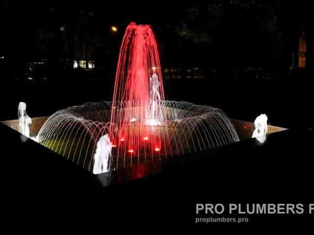 Round fountain at night with coloured LED lighting, central jet and a ring of arcing jets — fountain built by PRO PLUMBERS founder Viktor Zarubitskii (earlier work, Moscow region, 2019)