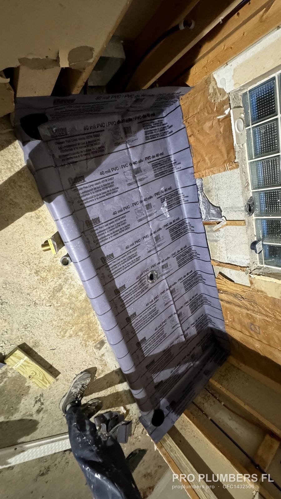 40 mil PVC shower pan liner laid in an open-framed shower below a glass block window in Sarasota, Florida by PRO PLUMBERS FL, LLC (licence CFC1432506)