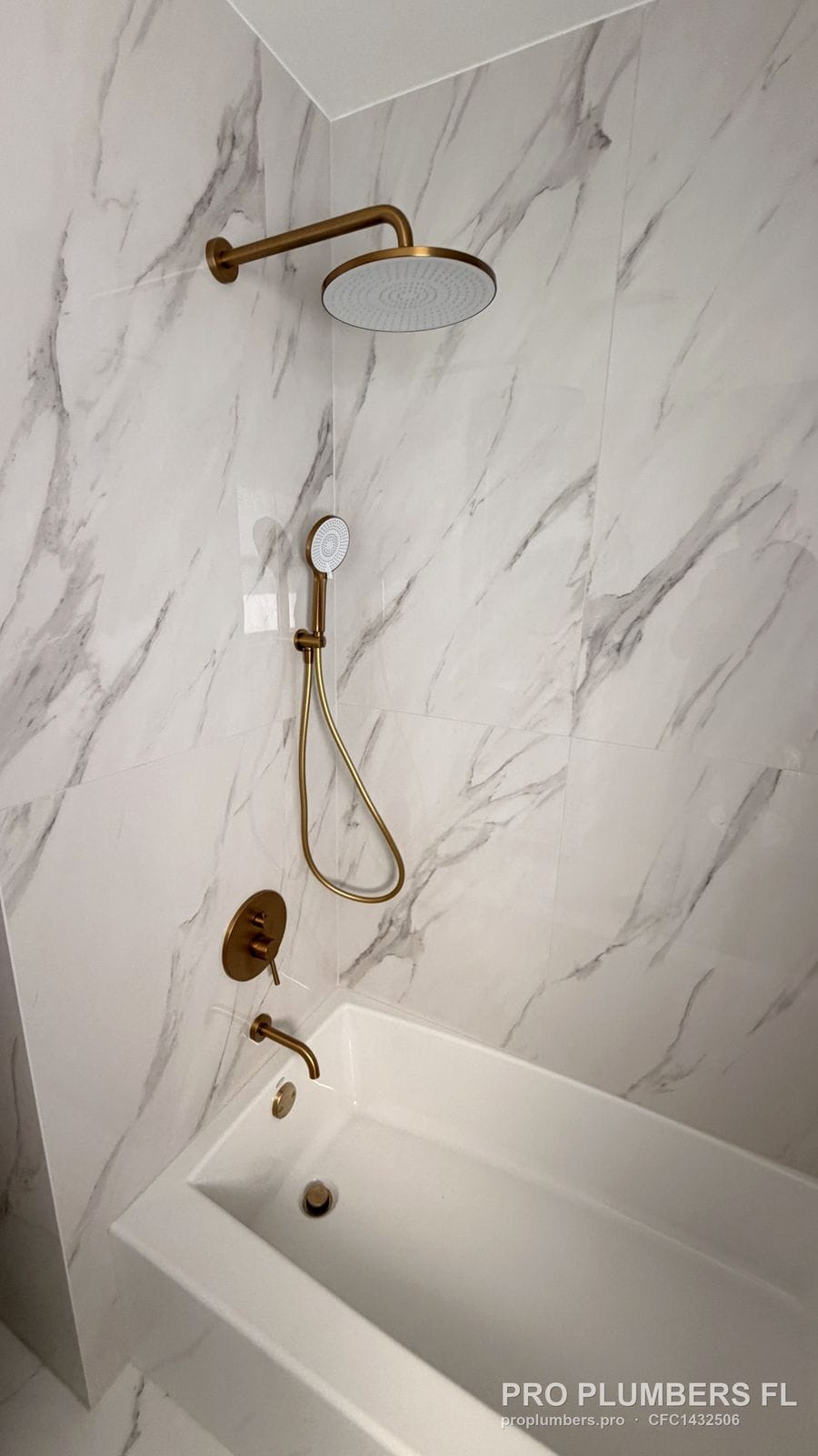 Brushed gold rain shower, handheld and tub trim over a soaking tub in Clearwater, Florida by PRO PLUMBERS FL, LLC (licence CFC1432506)