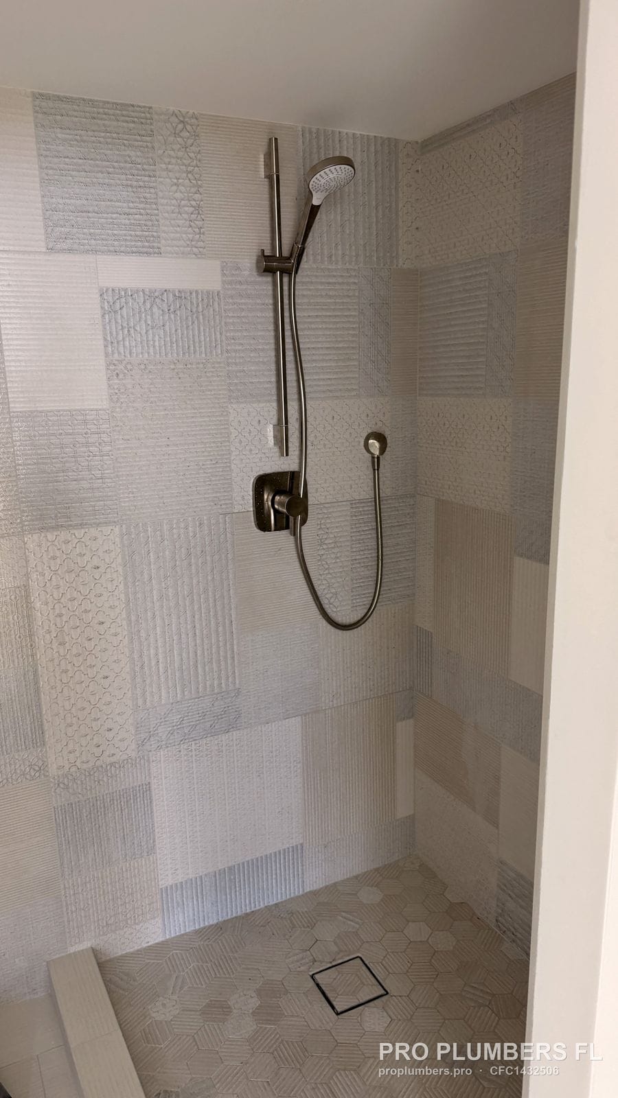Brushed nickel slide bar with handheld shower and valve trim in St. Petersburg, Florida by PRO PLUMBERS FL, LLC (licence CFC1432506)