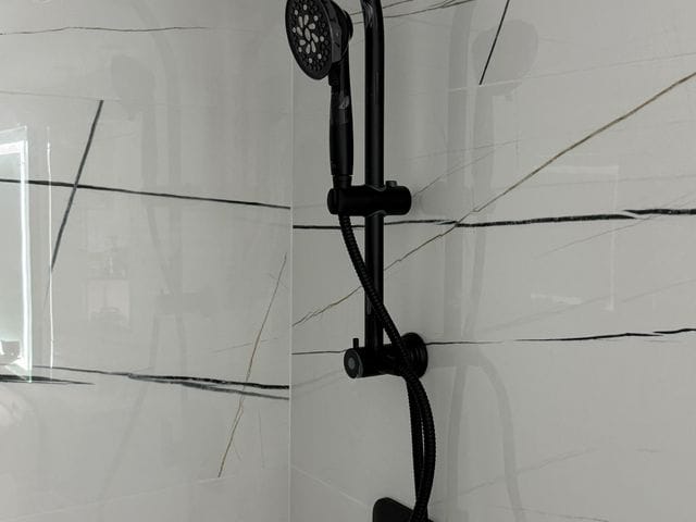 Matte black dual shower head with handheld and valve trim installed in Clearwater, Florida by PRO PLUMBERS FL, LLC (licence CFC1432506)