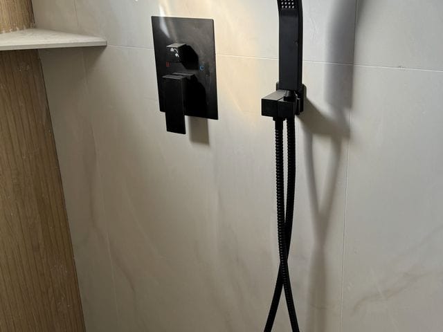 Matte black shower valve trim and handheld shower installed in Venice, Florida by PRO PLUMBERS FL, LLC (licence CFC1432506)