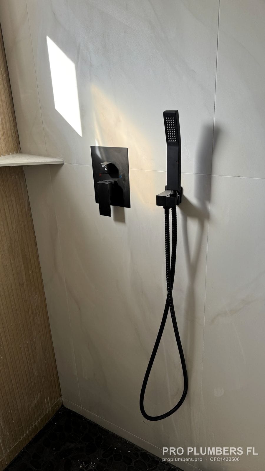Matte black shower valve trim and handheld shower installed in Venice, Florida by PRO PLUMBERS FL, LLC (licence CFC1432506)