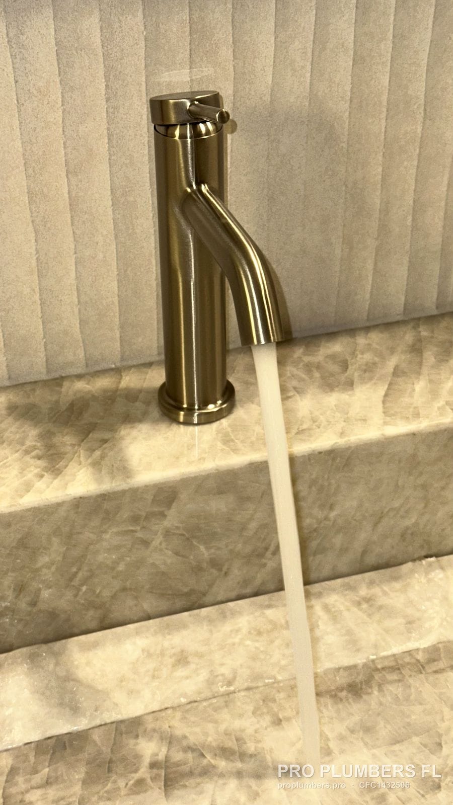 Brushed gold single-handle vessel faucet running water in Tampa, Florida by PRO PLUMBERS FL, LLC (licence CFC1432506)