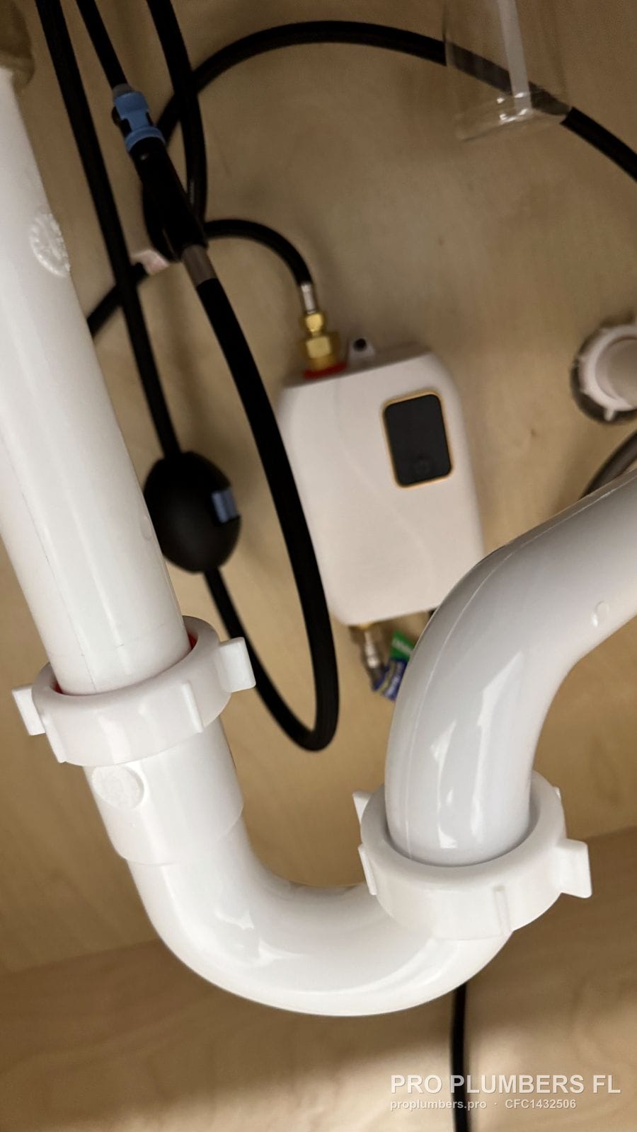 PVC P-trap under a sink next to a point-of-use electric water heater in Clearwater, Florida by PRO PLUMBERS FL, LLC (licence CFC1432506)