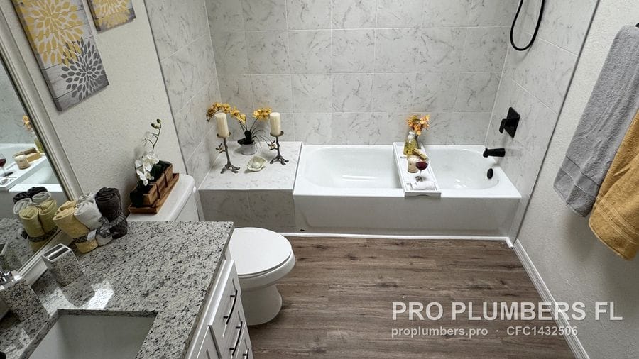 Renovated bathroom with vanity, toilet, bathtub and matte black shower trim in Kenneth City, Florida by PRO PLUMBERS FL, LLC (licence CFC1432506)