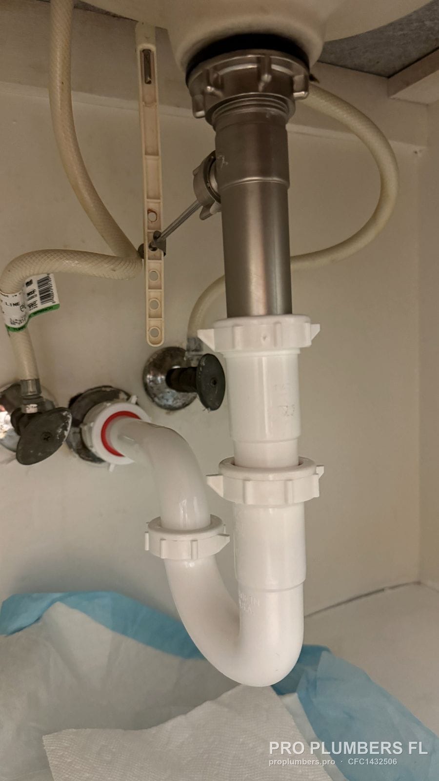 New PVC P-trap connected to a metal tailpiece under a vanity sink in Tampa, Florida by PRO PLUMBERS FL, LLC (licence CFC1432506)