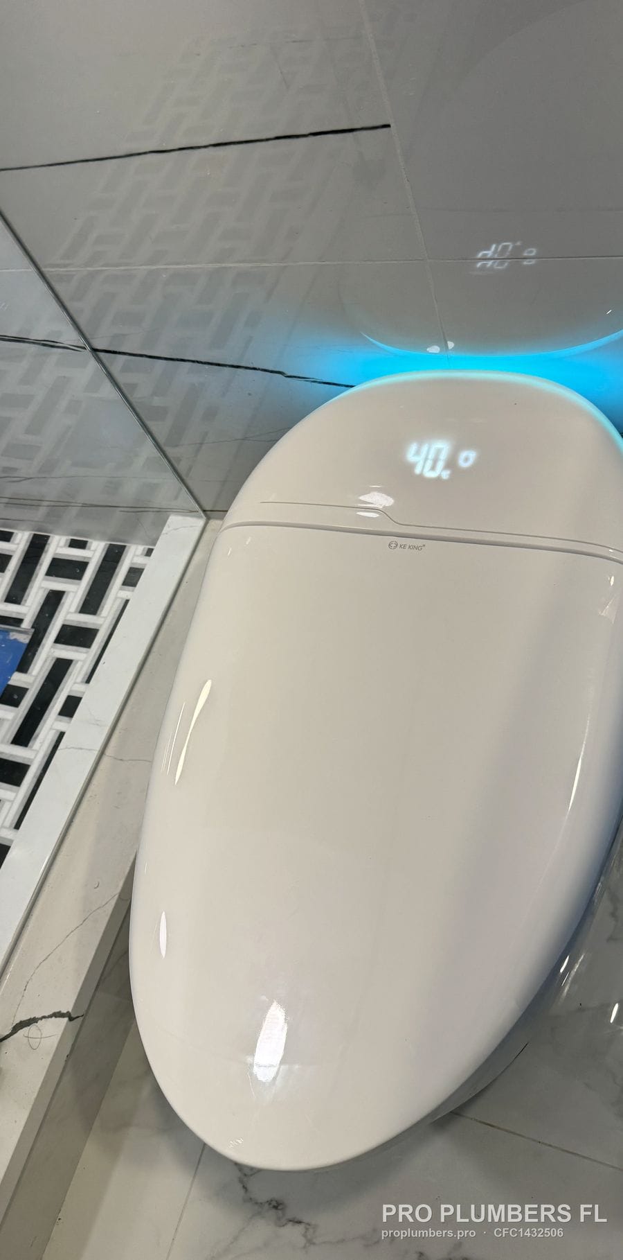 Tankless smart toilet with lit display showing 40 degrees and blue ambient light on marble-look tile in Clearwater, Florida by PRO PLUMBERS FL, LLC (licence CFC1432506)