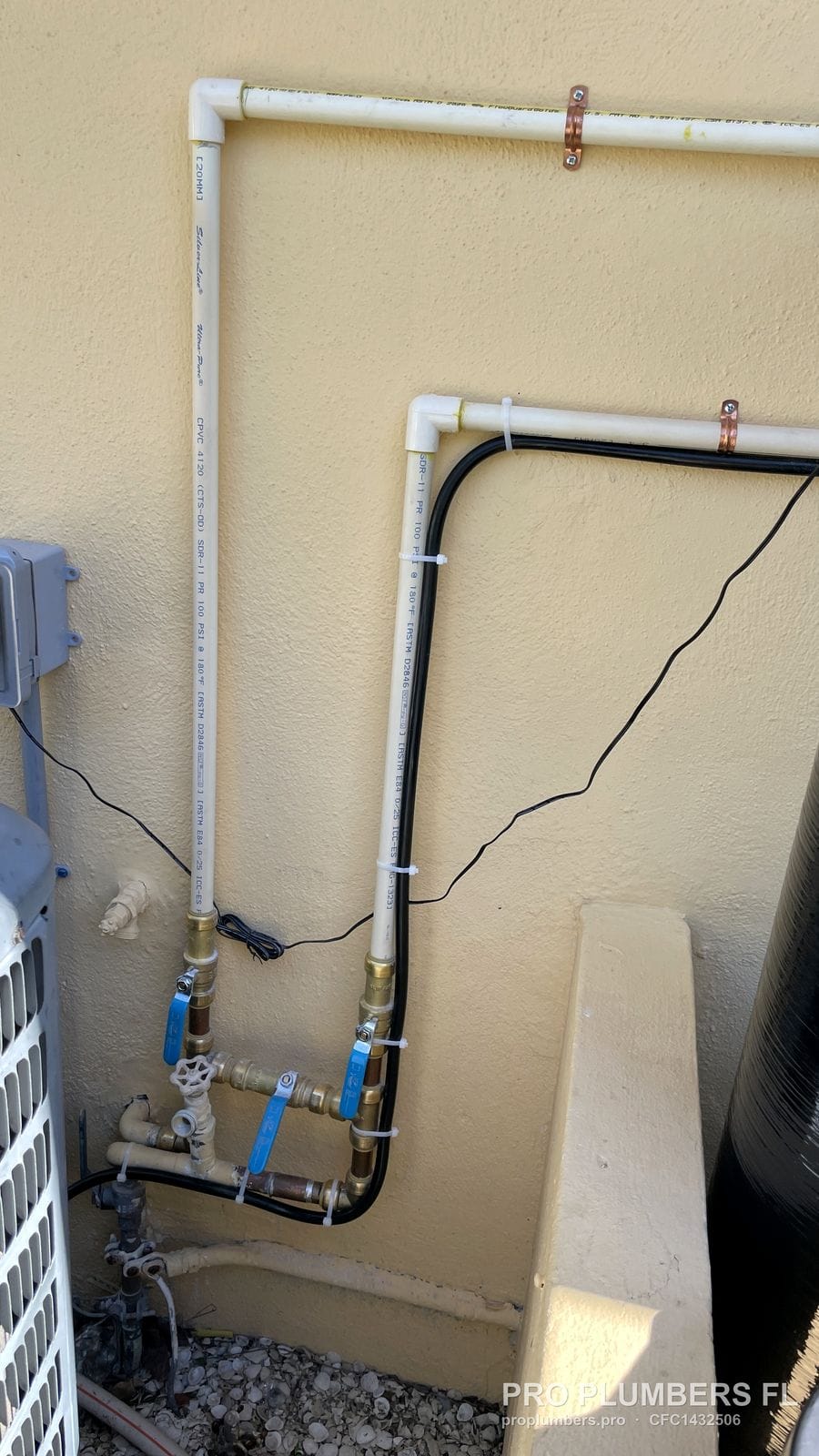 Brass bypass fittings with blue-handle ball valves at the base of a water softener supply loop in Redington Shores, Florida by PRO PLUMBERS FL, LLC (licence CFC1432506)
