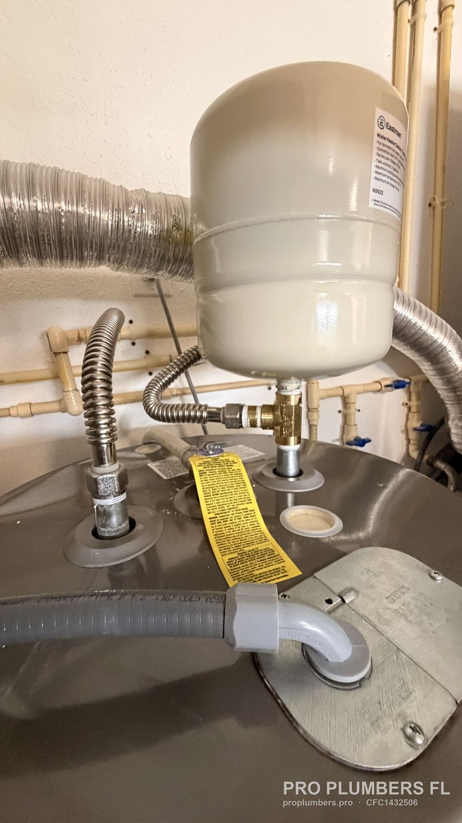 Thermal expansion tank on a brass tee above an electric tank water heater in St. Petersburg, Florida by PRO PLUMBERS FL, LLC (licence CFC1432506)