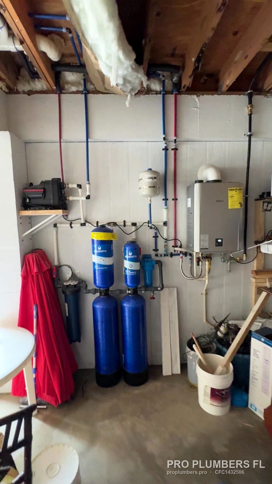 Utility room with gas tankless water heater, whole-house filtration tanks and booster pump in Englewood, Florida by PRO PLUMBERS FL, LLC (licence CFC1432506)