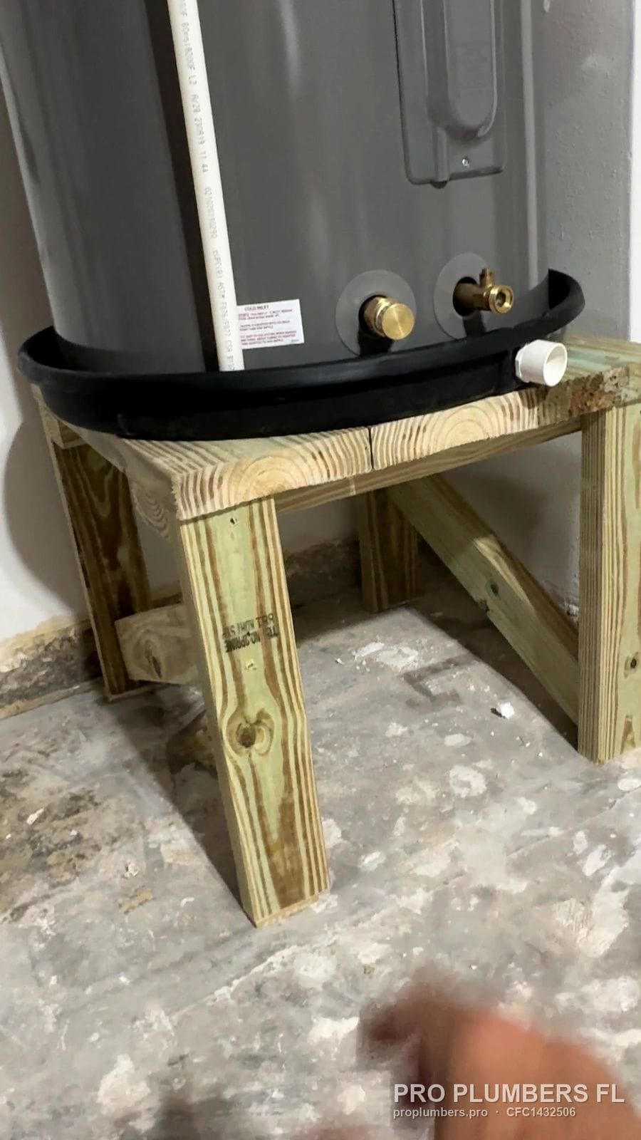Water heater drain pan on a custom treated-lumber stand in Belleair Beach, Florida by PRO PLUMBERS FL, LLC (licence CFC1432506)