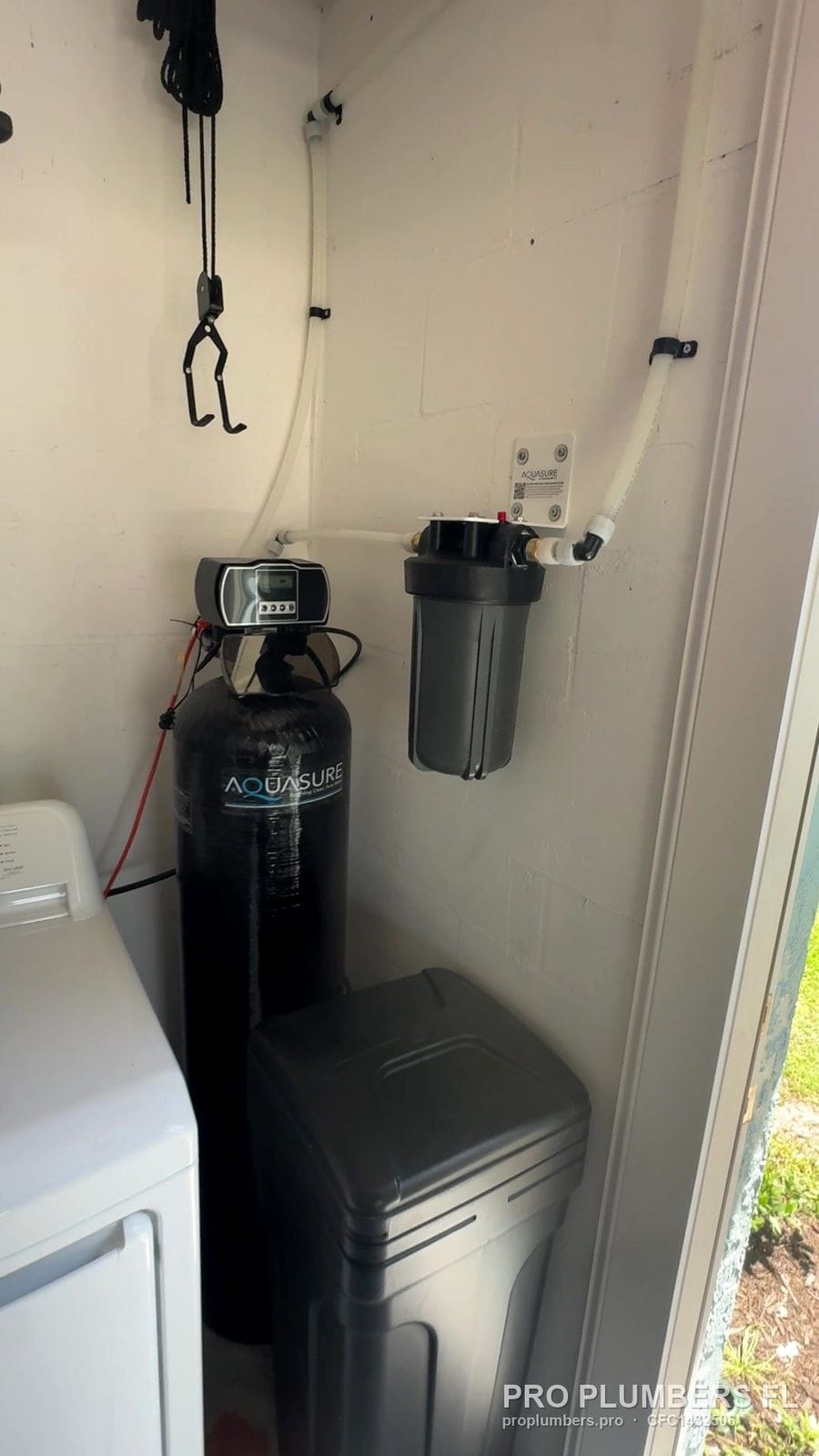Water softener and prefilter in a laundry closet next to the washer in South Pasadena, Florida by PRO PLUMBERS FL, LLC (licence CFC1432506)
