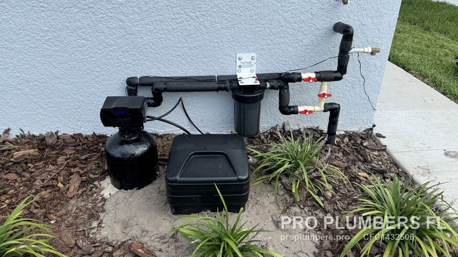 Recessed exterior water softener with foam-insulated supply piping, prefilter and bypass valves next to a hose bib in San Antonio, Florida by PRO PLUMBERS FL, LLC (licence CFC1432506)