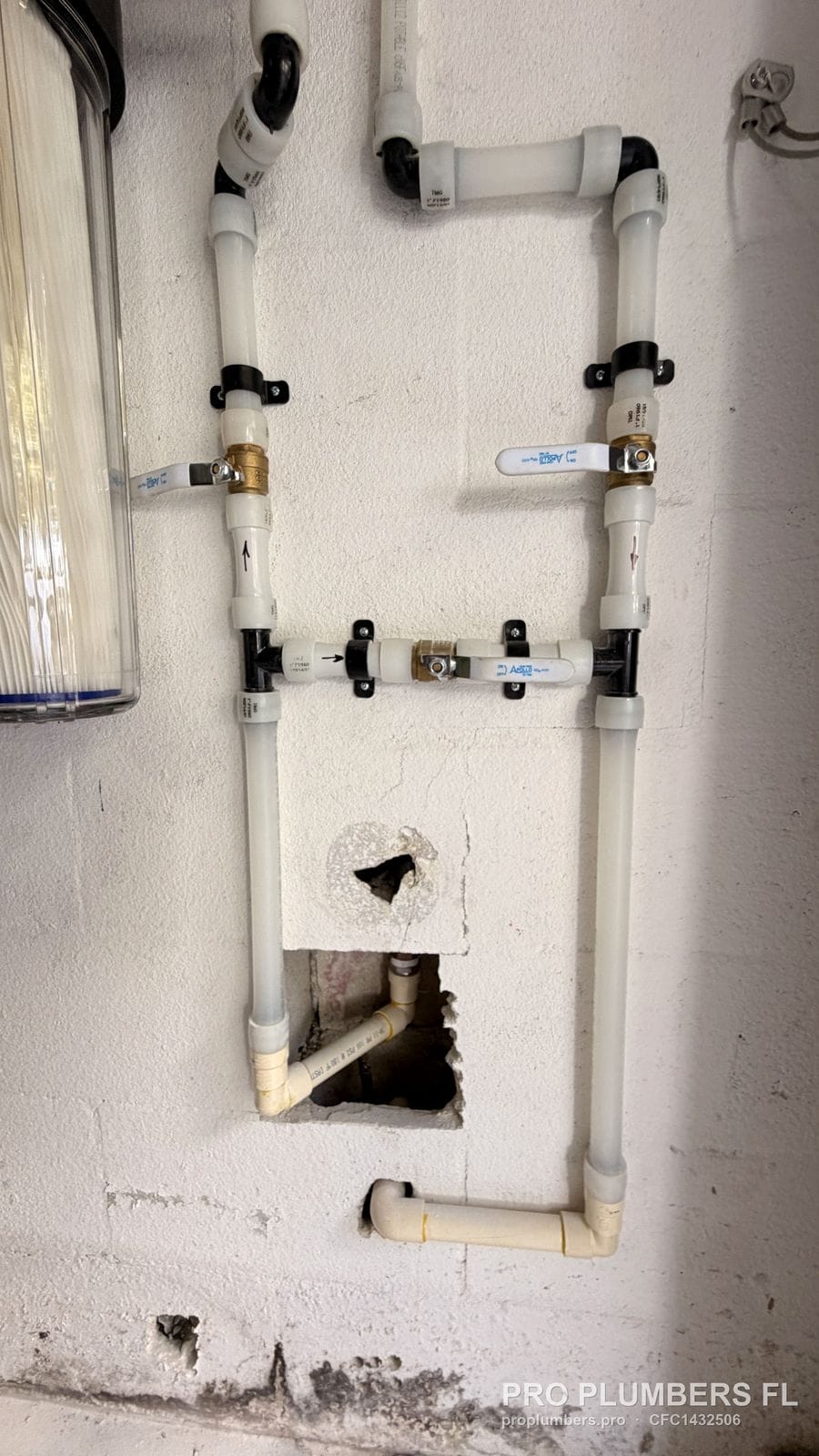 CPVC bypass manifold with three ball valves and an open access hole in a block wall in Westchase, Florida by PRO PLUMBERS FL, LLC (licence CFC1432506)